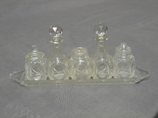 A 5 bottle cut glass cruet, raised on a rectangular tray