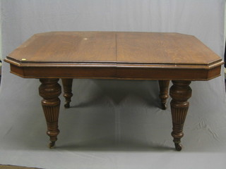 A Victorian oak lozenge shaped extending dining table, raised on turned and reeded supports 60" with 2 extra leaves