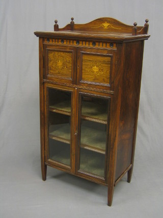 A Victorian rosewood music cabinet with three-quarter gallery, the upper section enclosed by inlaid panelled doors, the base fitted shelves enclosed by glazed panelled doors 22"