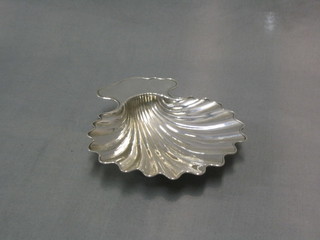 A silver plated scallop shaped butter dish, raised on 3 scallop supports