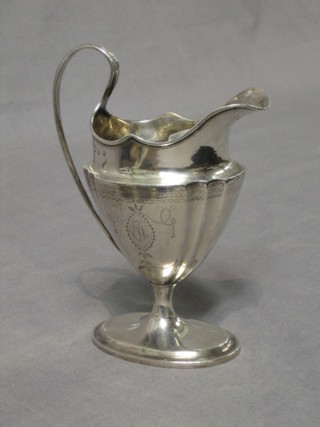 A George III Irish silver cream jug of tapering form engraved and raised on an oval spreading foot Dublin 1797, 6 ozs