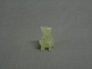 A jade coloured carved figure of a seated bear 2"