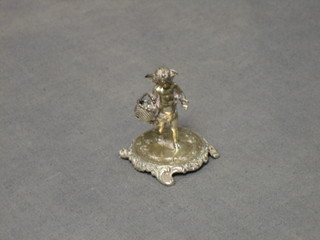 An Edwardian Continental silver table ornament in the form of a standing cherub with basket, raised on a circular base 1 2/2, London 1905 and with import mark