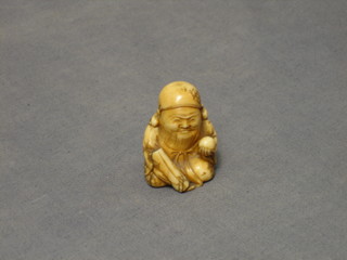 A 19th Century carved ivory netsuke in the form of a seated sage with ball 1 2/2"