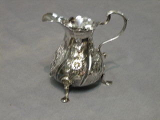 A Georgian embossed silver cream jug raised on hoof feet with engraved monogram (marks rubbed) 10 ozs