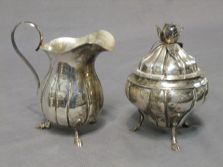 A Continental silver melon shaped sugar bowl with embossed body, raised on 3 hoof feet and with matching cream jug, marked 925 14ozs, 