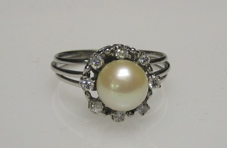 A lady's 18ct white gold or platinum dress ring set a large "pearl" surrounded by 8 small diamonds