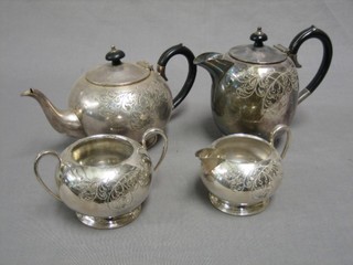 A 4 piece circular engraved silver plated tea service comprising teapot, hotwater jug, twin handled sugar bowl and cream jug