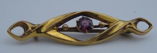A lady's gold bar brooch set an amethyst