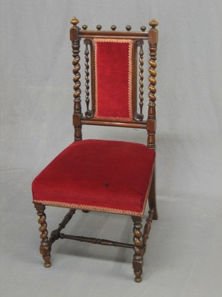 A Victorian rosewood nursing chair with spiral turned decoration, the seat and back upholstered in red material, raised on spiral turned and block supports