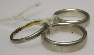 2 heavy silver rings and a gold coloured ring