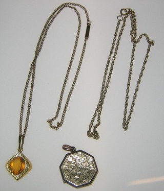 A "gold" locket, a gilt chain hung a yellow hard stone and a gilt metal chain