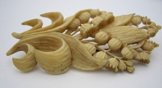 A pierced and carved ivory brooch in the form of a flower leaf