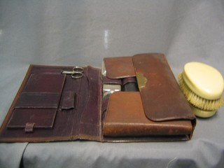A pair of military hair brushes with simulated ivory backs and a gentleman's travelling vanity set