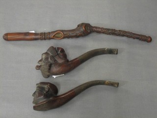 An Oriental carved hardwood pipe 12 1/2" and 2 carved pipes in the form of heads