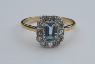A lady's 18ct gold dress ring set a rectangular cut aquamarine surrounded by 12 diamonds