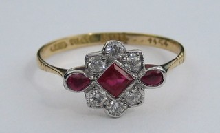 A  lady's 18ct gold dress ring set a square cut ruby supported by 2 tear cut rubies and 6 diamonds