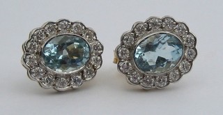 A pair of lady's 18ct gold ear studs set oval cut aquamarines surrounded by 14 diamonds (0/70/2.40ct)
