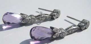 A pair of lady's white gold earrings set 3 circular cut diamonds, other cut diamonds and amethyst drops
