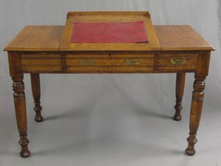 A 19th Century honey oak writing table with three-quarter gallery and sloped writing surface, fitted a drawer and raised on turned supports 48"
