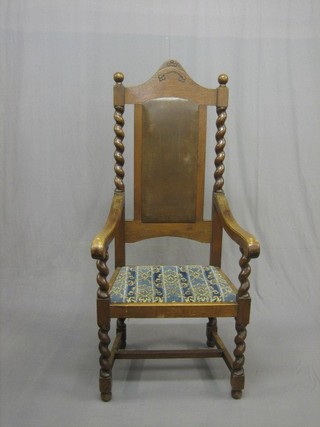 An oak throne chair with spiral turned decoration and upholstered drop in seat, raised on an H framed stretcher