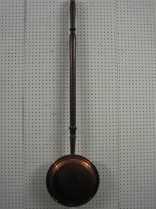 A 19th Century copper warming pan with turned fruit wood handle