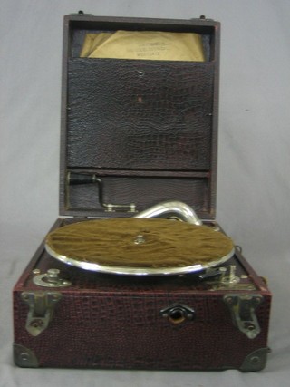 A Coronet manual gramophone contained in a red fibre case
