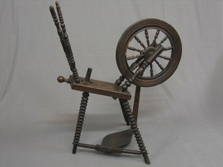 A 19th Century oak spinning wheel with bobbin turned decoration