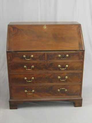 A Georgian mahogany bureau with fall front revealing a well fitted interior above  2 short and 3 long graduated drawers (some damage and patching to fall front, second drawer forced at some time) raised on bracket feet 26"