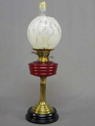 A 19th/20th Century red glass oil lamp reservoir, raised on a brass fluted column