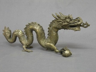A 20th Century Eastern gilt metal figure of a walking dragon with pearl 20"