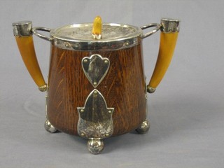 An oak circular biscuit barrel with silver plated mounts and horn handle