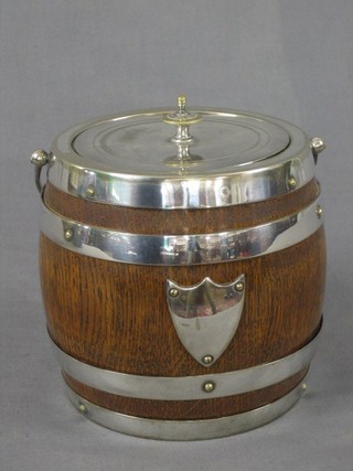 A circular oak biscuit barrel with silver plated mounts
