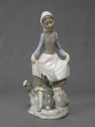 A Lladro figure of a standing peasant girl with rabbit, base impressed D24JU, 8"