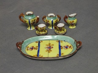 A Limoges miniature 8 piece tea service, comprising coffee pot (f), lidded sugar bowl, cream jug, 2 cups and 2 saucers and oval tray