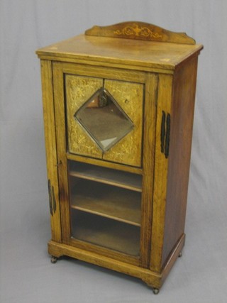 A Victorian bleached and inlaid rosewood music cabinet with raised back, the interior fitted shelves enclosed by a mirrored and glazed panelled door (some shrinkage to top panel) 21"