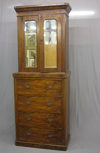 A Victorian walnut cabinet on chest, the upper section with moulded cornice, the interior fitted shelves enclosed by arch shaped bevelled plate mirrored doors, the base fitted 4 long drawers, raised on a platform base 33"