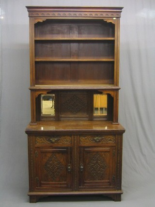 A Victorian oak dresser, the raised back with moulded cornice and fitted adjustable shelves above a niche with carved panel flanked by a pair of bevelled plate mirrors, the base fitted 2 drawers above a double cupboard, raised on bracket feet 43"