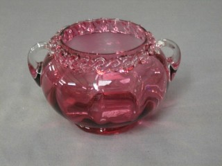 A cranberry circular glass bowl with clear glass handles 6"