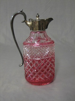 A cranberry cut glass claret jug with silver plated mounts