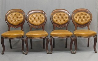 A set of 4 Victorian mahogany balloon back dining chairs with upholstered seats and backs, raised on French cabriole supports