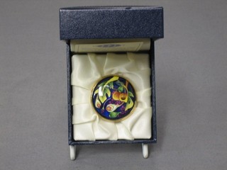 A modern circular Moorcroft brooch contained in a gilt metal mount, the reverse marked Moorcroft 05, 1 1/2", cased