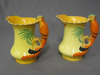 A pair of yellow glazed Art Pottery jugs, the handles decorated parrots 7 1/2"