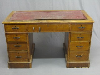 A Victorian honey oak kneehole pedestal desk with red inset writing surface, fitted 9 drawers 47"