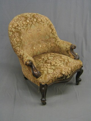 A Victorian carved walnut show frame tub back chair upholstered in brown floral material