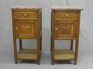 A pair of 19th Century French oak bedside cabinets with pink veined marble tops, fitted a drawer above a double cupboard 16"