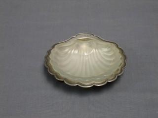 A silver scallop shaped butter dish, raised on 3 bun feet with glass liner, Birmingham 1907