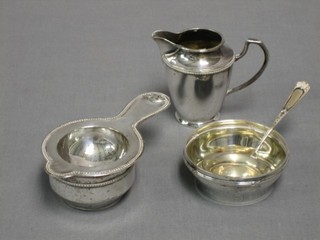 A Continental silver strainer and stand,  a Continental silver strainer, a small silver bowl and a silver plated cream jug
