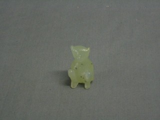 A jade coloured carved figure of a seated bear 2"