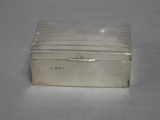 A silver cigarette box with engine turned decoration and hinged lid, 5 1/2"